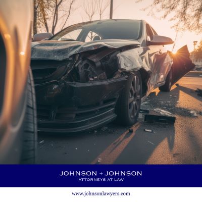Black car with severe front-end damage after a collision.