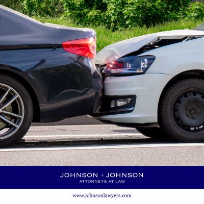 A white car rear-ending a black car during a car accident in Columbia