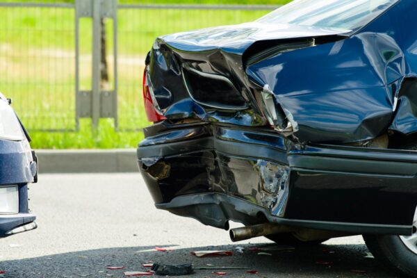 Car with heavy rear-end damage following an auto accident on a street.