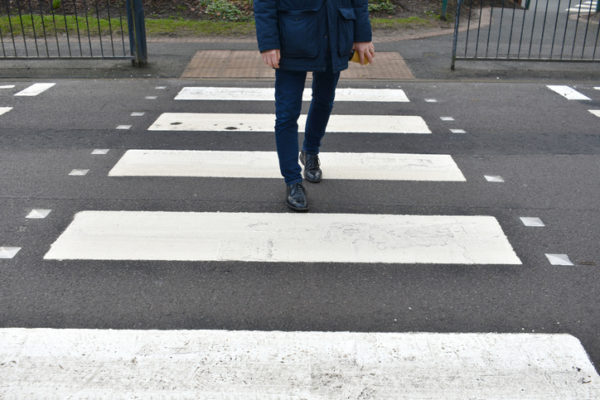 Pedestrian crossing street in crosswalk