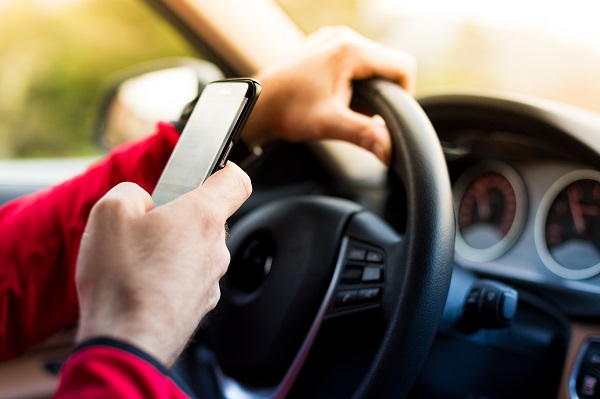 Dangerous texting and driving at the same time.