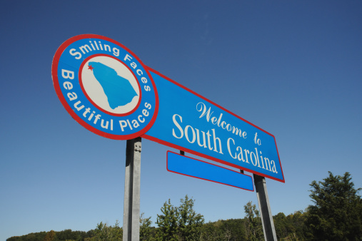 A road sign that reads "Welcome to South Carolina" with a blue sky in the background